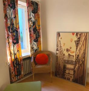 a room with a chair and a picture of a building at Cozy and peaceful Punavuori in Helsinki
