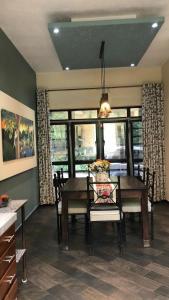 Un comedor con mesa y sillas y ventanas. en Casa Melodía Del Río-River-Escape, Mountians Views, en Puerto Vallarta