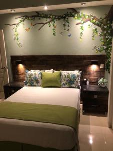 1 dormitorio con 1 cama con una rama en la pared en Casa Melodía Del Río-River-Escape, Mountians Views, en Puerto Vallarta