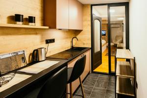 a kitchen with a counter and chairs in a room at Bascarsijaapart OWL parking included in Sarajevo