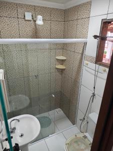 a bathroom with a shower with a sink and a toilet at Aconchegante casa de Temporada em Búzios. in Armacao dos Buzios +7 photos