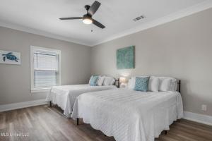 a bedroom with two beds and a ceiling fan at Beach Retreat in Gulfport +5 photos