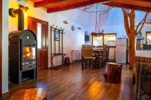 a living room with a fireplace and a dining room at Peter Cottage in Petrilaca de Mureş