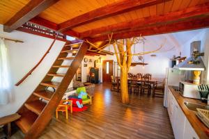 a living room with a spiral staircase and a tree at Peter Cottage in Petrilaca de Mureş