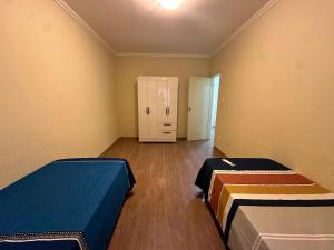 an empty room with two beds and a closet at Casa Aeroporto Premium Conforto e Conveniência para Sua Estadia in Campo Grande