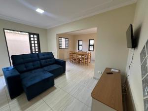 a living room with a blue couch and a table at Casa Aeroporto Premium Conforto e Conveniência para Sua Estadia in Campo Grande
