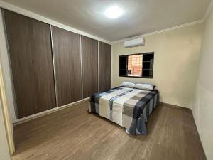 a bedroom with a bed in a room with a window at Casa Aeroporto Premium Conforto e Conveniência para Sua Estadia in Campo Grande