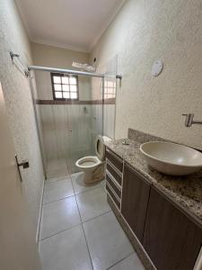 a bathroom with a sink and a toilet and a shower at Casa Aeroporto Premium Conforto e Conveniência para Sua Estadia in Campo Grande