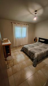 ein Schlafzimmer mit einem Bett und einem Tisch und einem Fenster in der Unterkunft Apartamento Urbano Bialet Masse in Bialet Massé