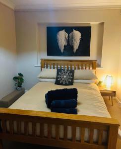 a bedroom with a large bed with angel wings on the wall at Little Teagues in East Grinstead