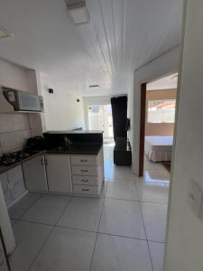 a white kitchen with a sink and a stove at Casa in Florianópolis