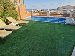 a backyard with a swimming pool and green grass at Claudia villa 2 in Agia Marina Nea Kydonias