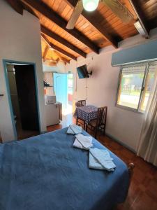 a bedroom with a blue bed and a table and chairs at Hosteria Alcala in La Falda