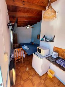 a small room with a kitchen and a microwave at Hosteria Alcala in La Falda