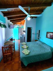 a bedroom with a green bed and a dining room at Hosteria Alcala in La Falda
