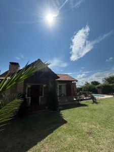 a house with the sun shining on a yard at Margaritas House in La Falda