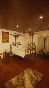 Vintage Coffee Estate 3 Bedrooms 1 Cottage في واياناد: غرفة نوم بها سرير مظلة وسجادة