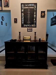 Vintage Coffee Estate 3 Bedrooms 1 Cottage في واياناد: خزانة ملابس سوداء في غرفة مع لافتة على الحائط