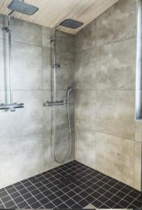 a shower in a bathroom with a tile floor at Luxury Privat Villa Merellä in Kalajoki