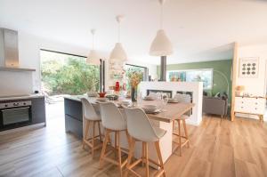 een keuken en eetkamer met een tafel en stoelen bij La Villa Nature Canopée du Lac in Seignosse