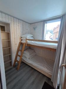 a small room with a bunk bed and a window at Résidence Digitale - 3 pièces pour 6 personnes - Piscine, sauna et Parking Privé in Plagne 1800 +26 photos