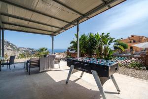 un tavolo da biliardo su un patio con vista sull'oceano di The Lemon Tree a Taormina