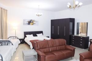 a hotel room with a couch and a bed and a chair at FleXmo Homes in Dubai