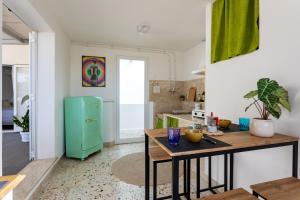 eine Küche mit einem Tisch und einem grünen Kühlschrank in der Unterkunft Il Nido di Frisella in Marsala + 5 Fotos
