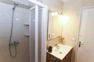 Un baño con ducha, lavabo y espejo. en Dms Planetcostadorada, en La Pineda 15 fotos más
