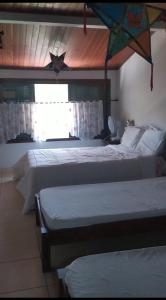 a bedroom with two beds and a kite hanging from the ceiling at Penedo Reserva Guest House in Penedo +11 photos