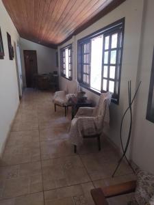 a hallway with a table and chairs and windows at Penedo Reserva Guest House in Penedo