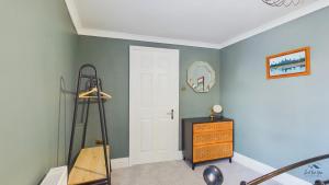 a room with a white door and a wooden dresser at Simeon Sands Coastal Escape in Ryde