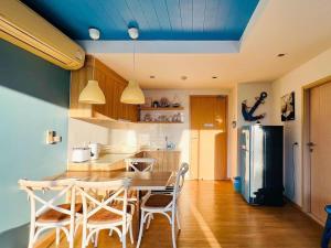 eine Küche mit Tisch und Stühlen und einem Kühlschrank in der Unterkunft บ้านแสนคราม หัวหิน Baan San Kraam Hua Hin in 