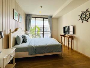 ein Schlafzimmer mit einem Bett mit einer Uhr an der Wand in der Unterkunft บ้านแสนคราม หัวหิน Baan San Kraam Hua Hin in 