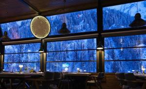 a restaurant with a view of snow covered trees through the windows at Ayder Villa de Pelit Hotel in Ayder Yaylasi