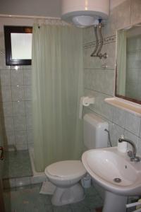 a bathroom with a white toilet and a sink at Guesthouse Santor in Lastovo
