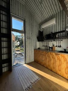 a kitchen with a door open to a patio at Jūras Krasti Bohemija in Jūrmalciems