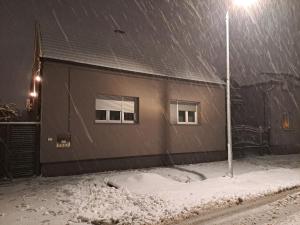 a building in the snow with a street light at Cibalae Residence, Self Check-In in Vinkovci