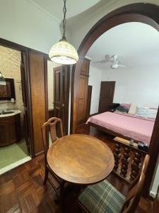 a dining room with a table and a bed at Petrópolis APT Suíte Compacta Palácio Quitandinha in Petrópolis