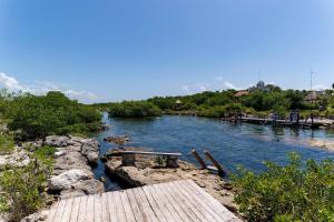 a view of a river with a wooden bridge at Villa con piscina y acceso a laguna Yalku, Akumal in Akumal +86 photos