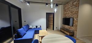 a living room with a blue couch and a brick wall at Apartament centrum 17 in Nowy Sącz