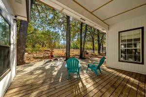 two green chairs sitting on a porch with trees at Entire Home! Fantastic Kitchen! 3 Full Baths in Mead