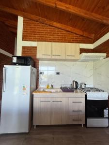 een keuken met een witte koelkast en een spoelbak bij Cabañas AdamiS in Villa Cura Brochero +4 foto's