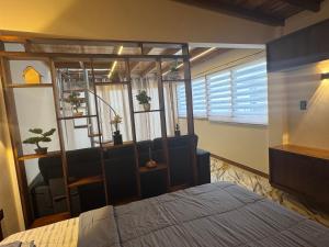 a bedroom with a bed and a chair and a window at Las Olas del Surf in Ayampe