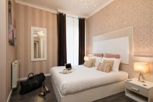 Un dormitorio con una gran cama blanca y una ventana en San Pietro Suites, en Roma