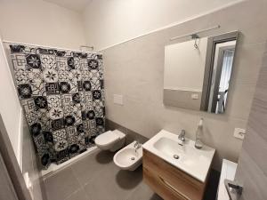 a bathroom with a sink and a toilet and a mirror at Picasso in Tracoccia