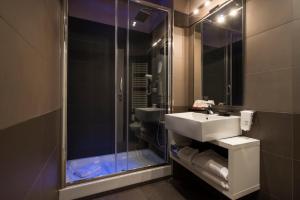 a bathroom with a shower, sink, and tub at San Pietro Suites in Rome