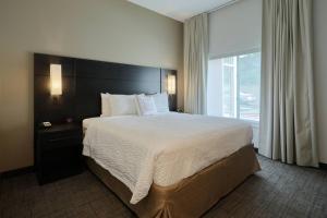 a bedroom with a large bed and a large window at Residence Inn by Marriott Harrisburg North in Harrisburg +28 photos