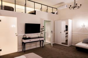 um quarto com uma secretária, uma televisão e um espelho em Imagine Apartments na Cracóvia