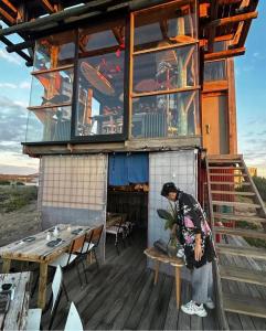 una mujer parada en una mesa frente a un edificio en Posada El Pepe, en José Ignacio